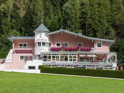 a pink hotel with flowers on top of it at Apart Relax in Längenfeld