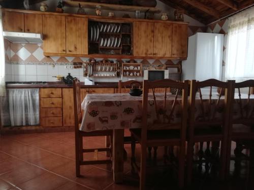 cocina con mesa, sillas y nevera en Casa Osciris, en El Cercado