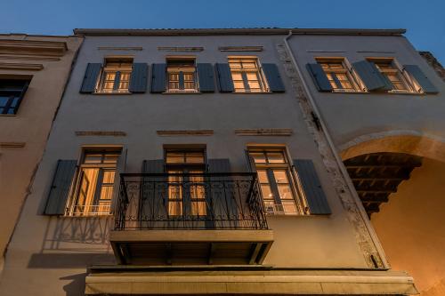 a tall building with a balcony and a window at Malmo Historic Hotel in Chania Town