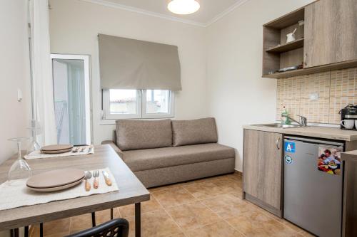a kitchen and living room with a couch and a table at StayInn Luxury Apartments in Nea Kalikratia