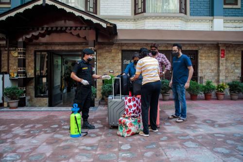 a group of people standing around a police officer with luggage at Muscatel Grand Silkroute - 300 Mts from MG Marg in Gangtok