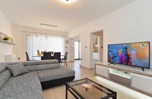 a living room with a couch and a large screen tv at House Pula 2080 in Pula