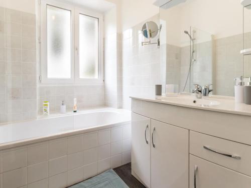 uma casa de banho branca com uma banheira e um lavatório em Gîte Guémené-Penfao, 3 pièces, 4 personnes - FR-1-306-875 em Guéméné-Penfao