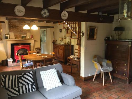 - un salon avec un canapé, une table et une cheminée dans l'établissement Maison de campagne rénovée avec jardin, à proximité de Valençay et du Zoo de Beauval - FR-1-591-287, à Veuil