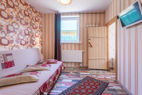a bedroom with two beds and a tv and a window at Izborsk Park in Izborsk