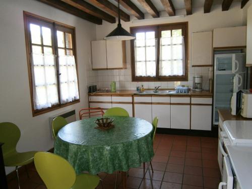 a kitchen with a table with a green table cloth on it at Maison de charme en pleine nature avec étang de pêche, proche d'Authon-du-Perche, animaux admis. - FR-1-581-1 in Authon-du-Perche