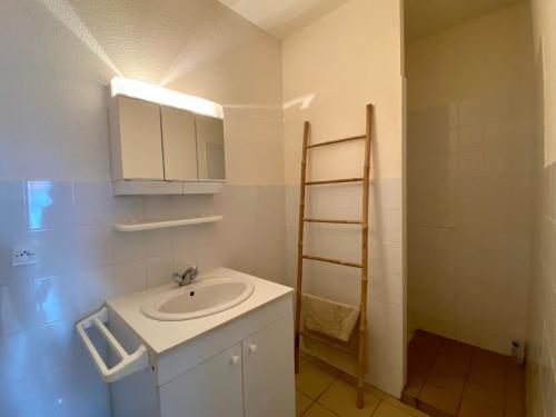 een witte badkamer met een wastafel en een douche bij Gîte Alleyrac, 4 pièces, 6 personnes - FR-1-582-66 in Alleyrac
