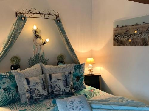 1 dormitorio con 1 cama con almohadas azules y blancas en Gîte Brem, 5 pièces, 8 personnes - FR-1-426-103, en Brem-sur-Mer