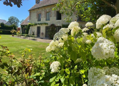 a garden with white flowers in front of a house at La Maison d'Aline - Honfleur - Maison d'Hôte De Charme A La Normande in Honfleur