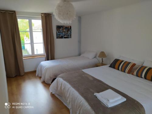 a bedroom with two beds and a window at Gîte Germonville, 4 pièces, 6 personnes - FR-1-584-167 in Germonville