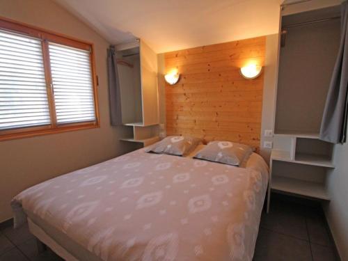 een slaapkamer met een bed en een houten muur bij Gîte Cornimont, 2 pièces, 2 personnes - FR-1-589-41 in Cornimont