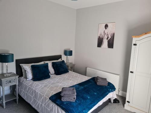 a bedroom with a bed with blue pillows at AMY'S Place Charming 3 Bed House Donegal in Donegal