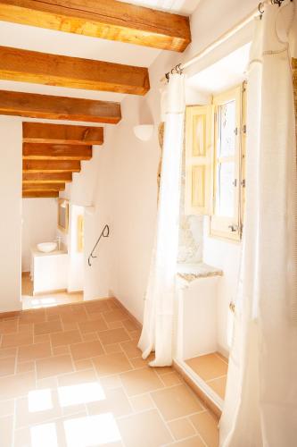a bathroom in a house with white walls and wooden ceilings at Nits de Bosc in Vilassar de Dalt