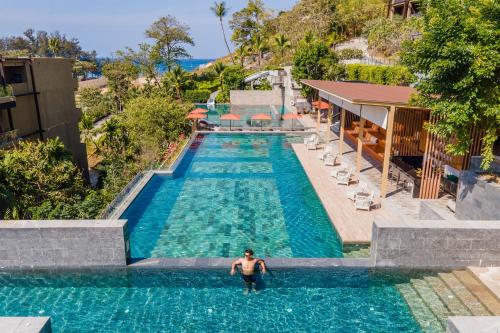 a man standing in the water in a swimming pool at Sunsuri Phuket - SHA Plus in Nai Harn Beach