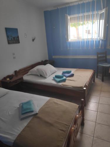 2 Einzelbetten in einem Zimmer mit Fenster in der Unterkunft Angela - Zoi Rooms in Skiathos-Stadt