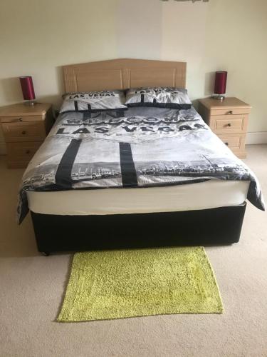 a bedroom with a bed with a rug and two night stands at Private room Bishop Norton in Market Rasen