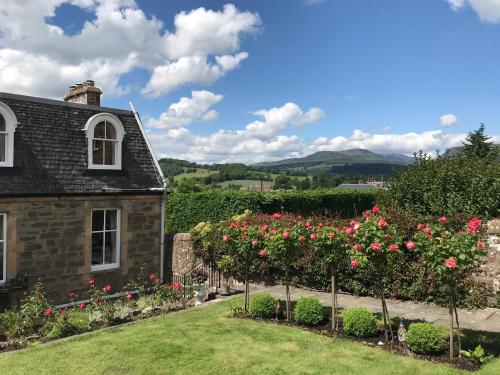 a garden in front of a house with roses at Leven House Bed and Breakfast in Crieff