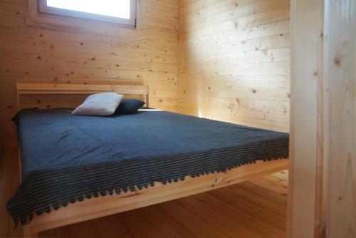 什文托伊的住宿－Jūros terasos，小木屋内一间卧室,配有一张床