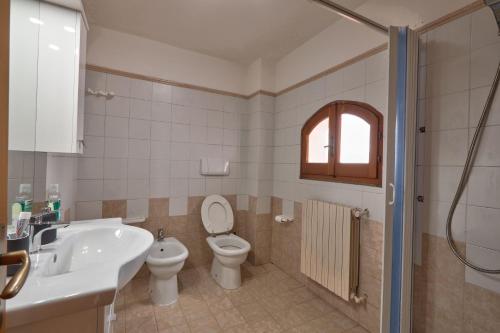 a bathroom with a toilet and a sink and a tub at Appartamento Zia Lucia in Terme Vigliatore