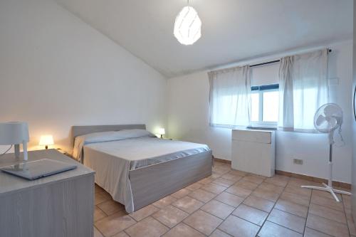 Schlafzimmer mit einem Bett und einem Schreibtisch mit einem Ventilator in der Unterkunft Appartamento Zia Lucia in Terme Vigliatore