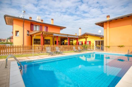 eine Villa mit einem Pool vor einem Haus in der Unterkunft Villa Camporosso in Colà di Lazise