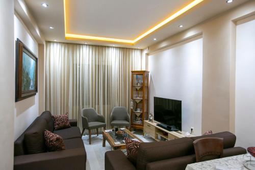 a living room with a couch and a television at Moza House in Kavala