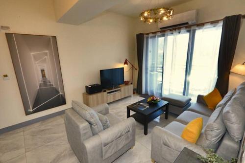 a living room with a couch and chairs and a tv at Modern Chic in Hengchun