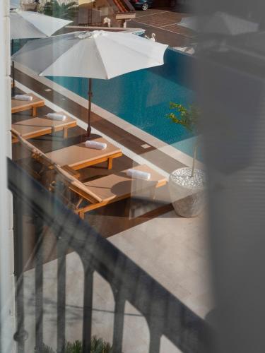 a view of a pool with tables and an umbrella at Garden Recovery in Sveti Stefan
