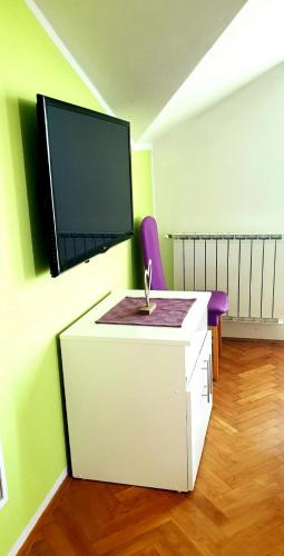a bathroom with a sink and a tv on a wall at IstraNova Apartments in Rovinj