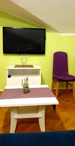 a living room with a white table and a purple chair at IstraNova Apartments in Rovinj