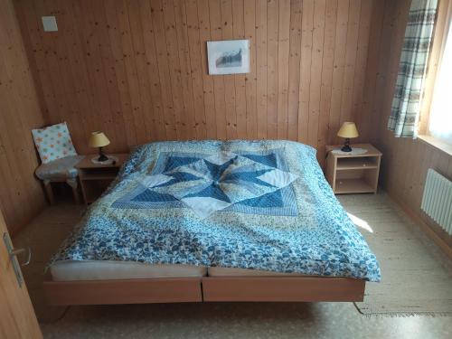 ein Schlafzimmer mit einem Bett mit einer Decke darauf in der Unterkunft 2 Zimmerwohnung Homestay Brienz Spanischgässli in Brienz