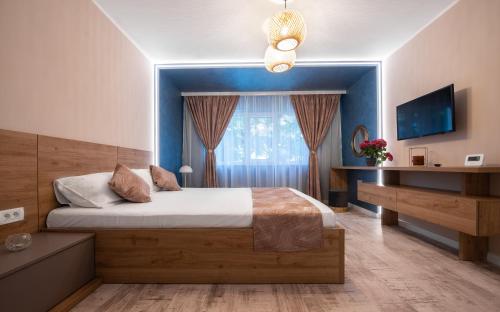 a bedroom with a large bed with a blue wall at Anastasia SeaSide in Mangalia