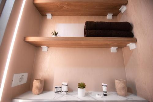 a bathroom with a shelf with towels and plants at Anastasia SeaSide in Mangalia