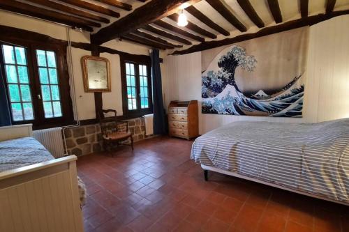 1 dormitorio con 1 cama y una pintura de una ola en La Lanterne: Grande maison à deux pas de la mer, en La Chapelle-sur-Dun