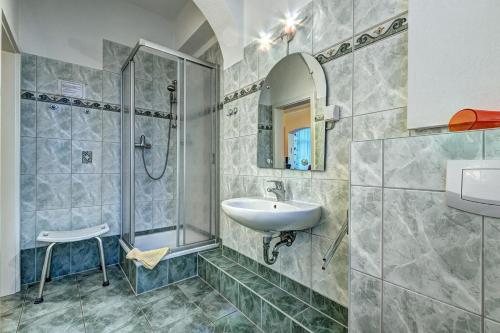 y baño con lavabo y ducha. en Pension Mittag en Heringsdorf