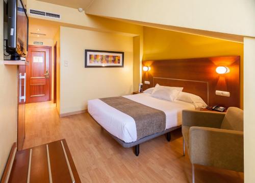 a hotel room with a bed and a chair at Hotel Andia in Orcoyen