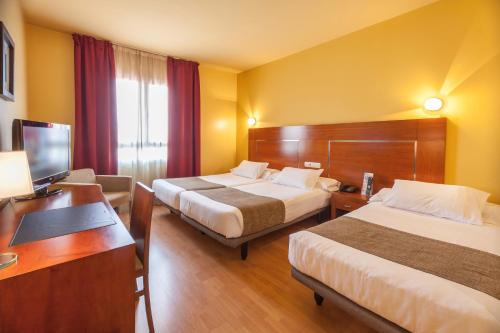 a hotel room with two beds and a desk at Hotel Andia in Orcoyen