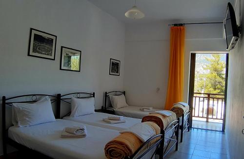 two twin beds in a room with a window at Platanos Rooms in Anopoli Sfakion