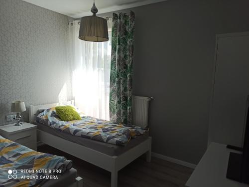 een kleine slaapkamer met een bed en een raam bij Centrum Haus in Giżycko