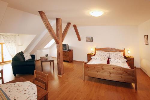 a bedroom with a wooden bed and a living room at Penzion U Chodskeho Hradu in Domažlice