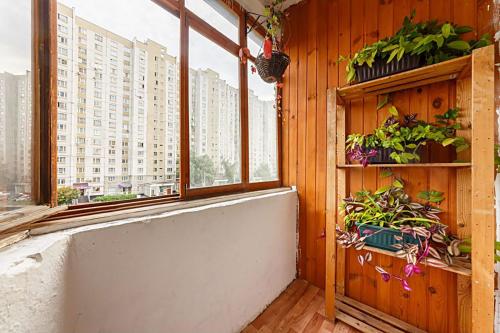 モスクワにあるApartment Hanaka Kluchevaya 20の植物のある窓、バスタブが備わる客室です。