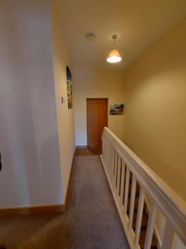 a hallway with a wooden door and a stair case at Red Door Townhouse in Galway