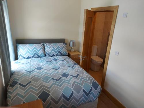 a bedroom with a bed and a bathroom with a toilet at Red Door Townhouse in Galway