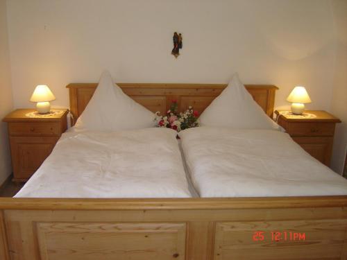 ein Bett mit zwei Kissen und Blumen darauf in der Unterkunft Ferienwohnung Haus Bergrast in Berchtesgaden