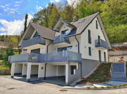a large white house with blue balconies at Villa Recica North in Bled