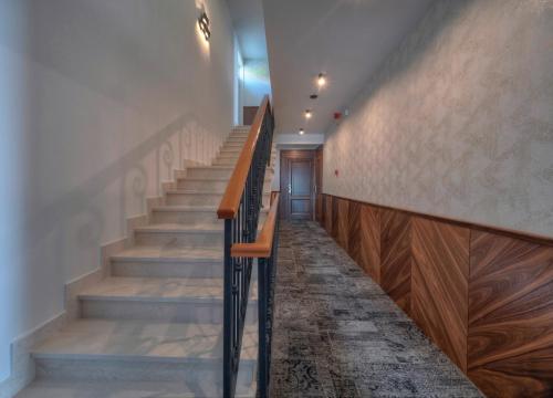 a staircase in a building with wooden steps and a door at Garden Recovery in Sveti Stefan
