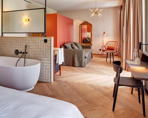 a hotel room with a bath tub and a bedroom at Hotel Restaurant Seehof in Küssnacht