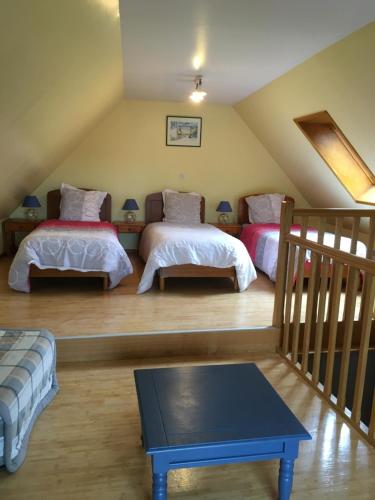 a attic room with two beds and a staircase at Ferme BROCART in Bouvines