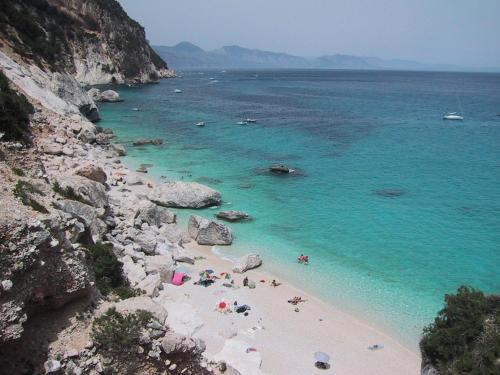 a group of people on a beach in the water at Stella Del Sud in Cuglieri