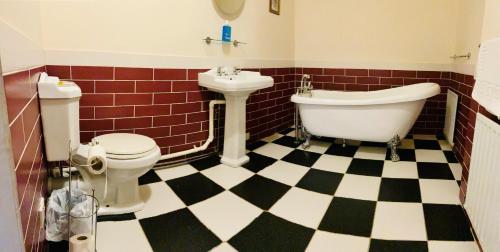 a bathroom with a tub and a toilet and a sink at The Royal Victoria & Bull Hotel in Rochester